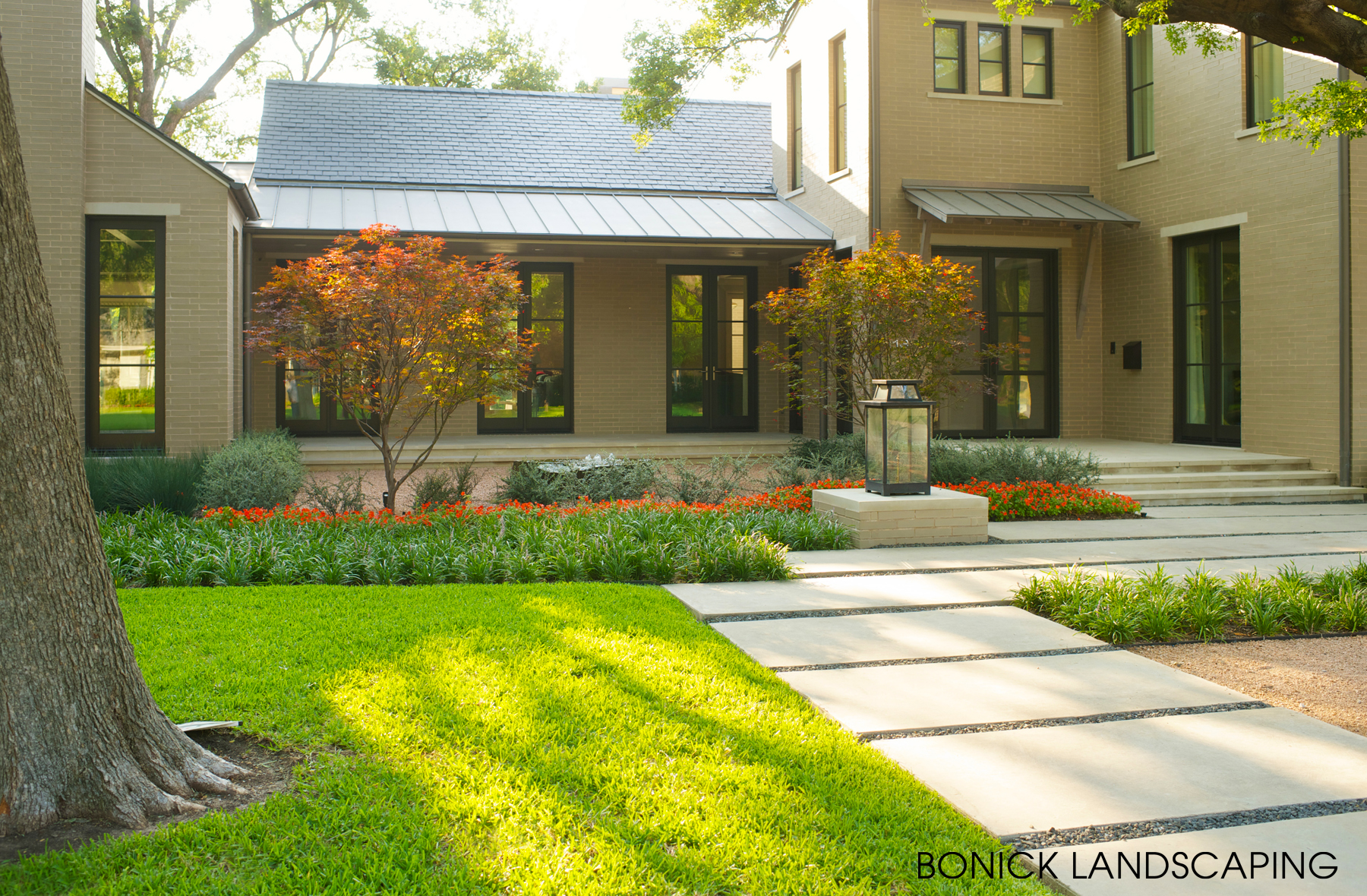 Front yard for a contemporary home in Dallas features smooth concrete slab pavers and minimalist, clean landscaping.