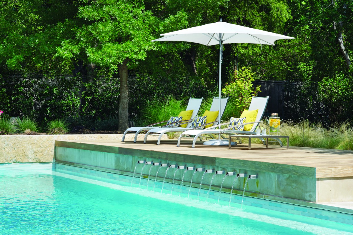 Contemporary pool design with ipe sun deck and stainless steel scuppers in Dallas, TX