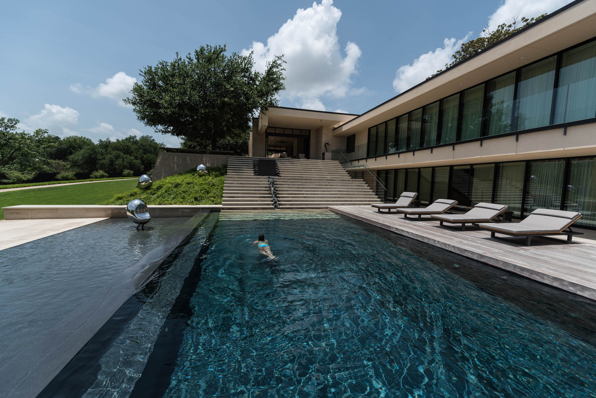 Negative edge pool with ipe deck and Brandon Oldenburg sculptures.