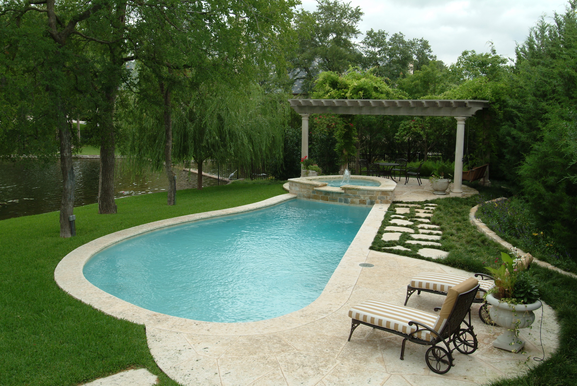 Stamped concrete patio and swimming pool by Dallas landscape designer Bonick Landscaping.