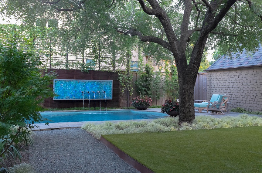Modern backyard landscape design with pool, fountain and lush plantings.