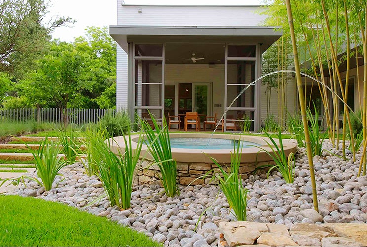 Colorado River Rock Gravel used for landscaping a flower bed that surrounds a small spa in a backyard residence in Dallas, Texas.