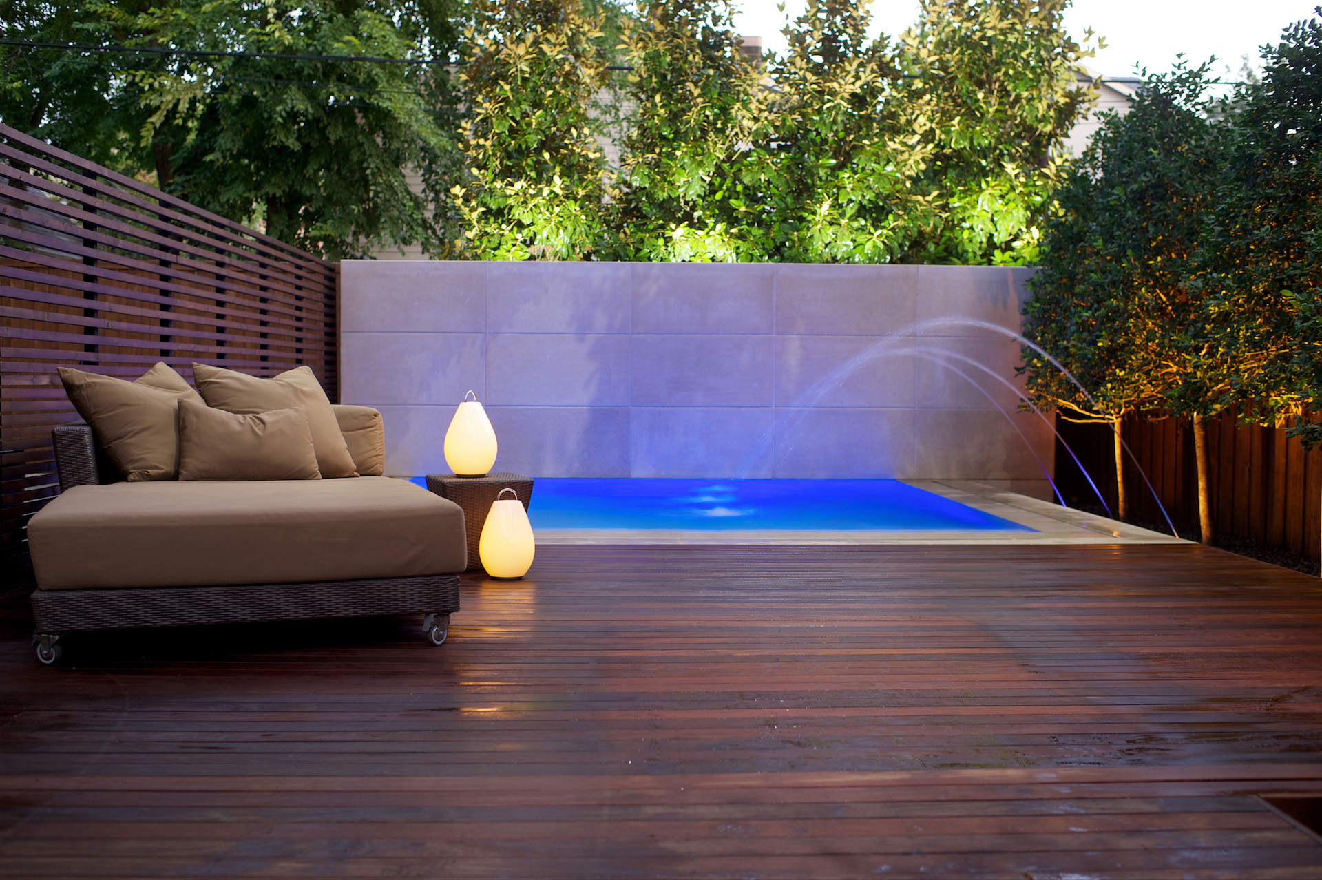 Contemporary pool with decorative limestone wall and led lighting.