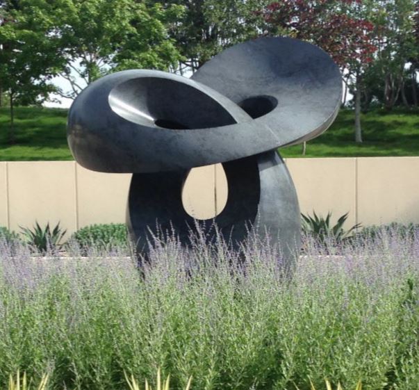 Contemporary sculpture surrounded by ornamental grasses.