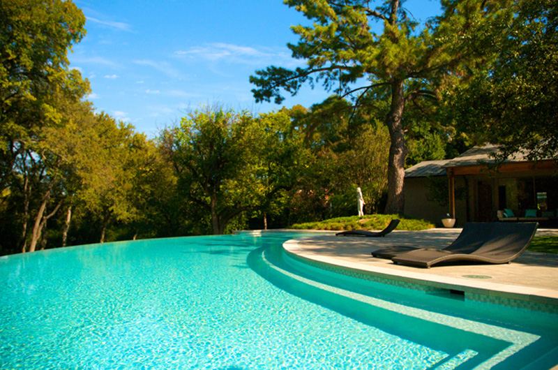 Infinity edge pool with woods in background.