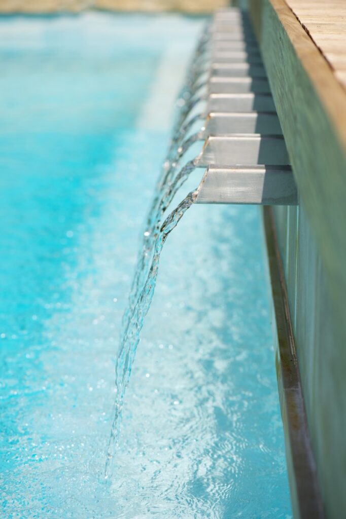 Closeup of Stainless steel scuppers pool water feature in Dallas, TX